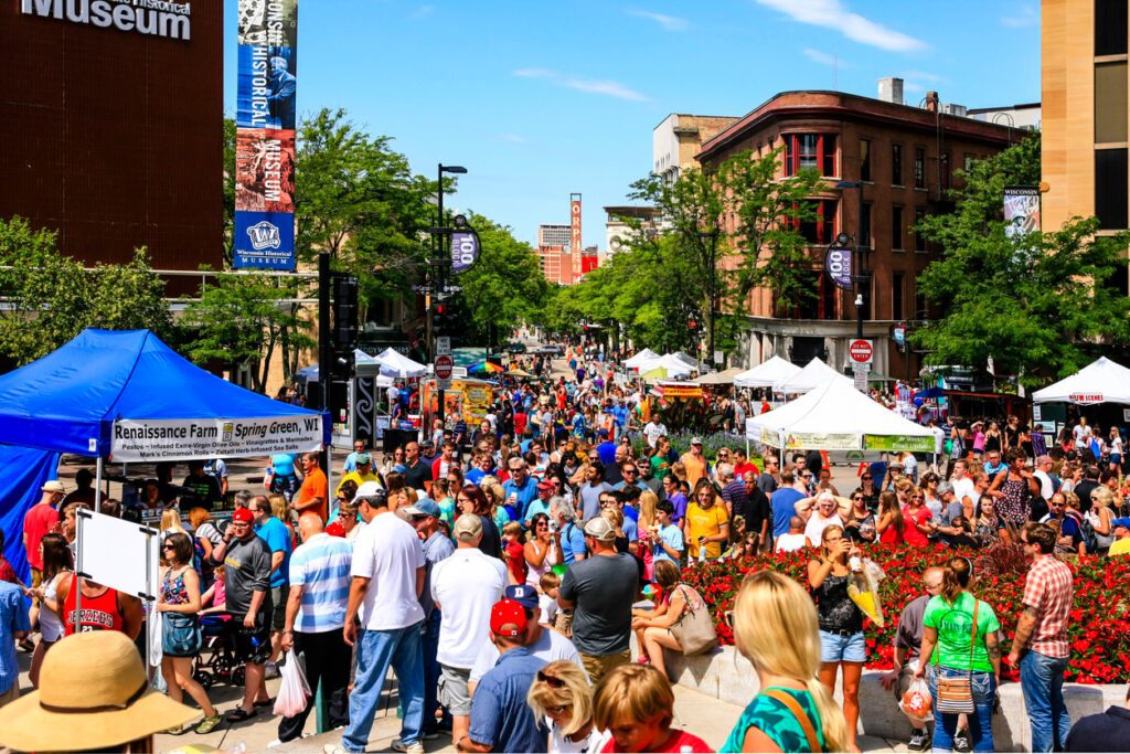 Busy outdoor market with tents and people.