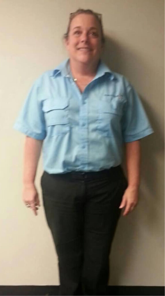 Smiling woman in light blue uniform shirt.