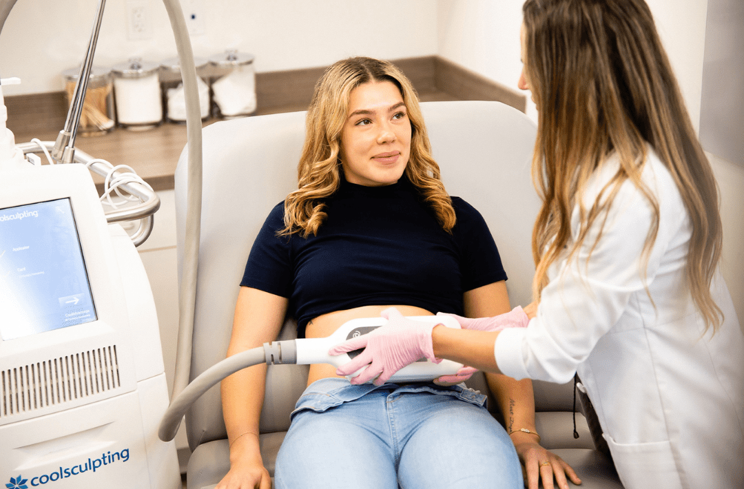 Woman receiving CoolSculpting treatment in clinic.